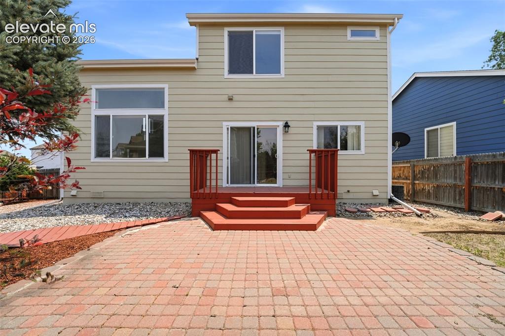 7904 Coffee Road Peyton, CO 80831 - Photo 32 of 48 Rear exterior featuring a brick paver patio, multi-level red-stained deck, and sliding glass door access