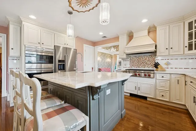 a kitchen with stainless steel appliances granite countertop a sink a stove and a refrigerator