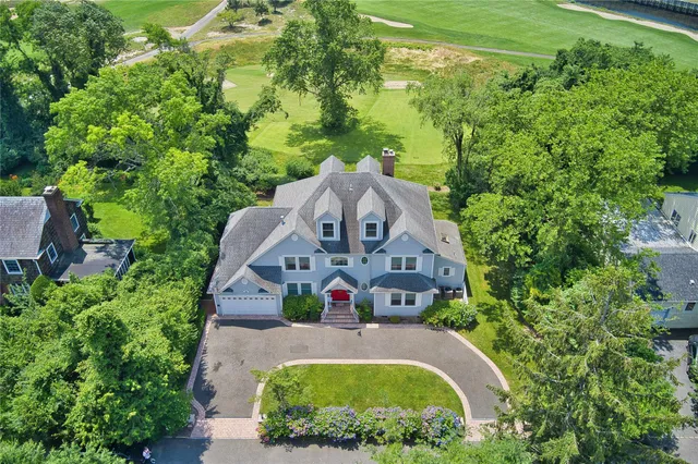 an aerial view of a house with a yard and large trees