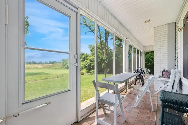 a view of an outdoor dining space with furniture and floor to ceiling window