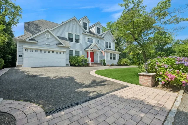 a front view of a house with a garden and yard
