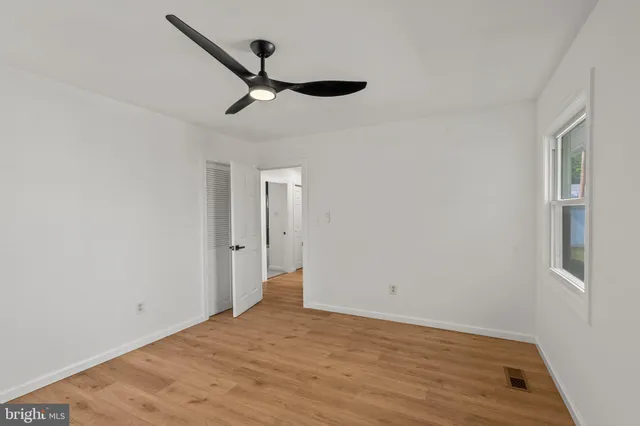 a view of empty room with wooden floor