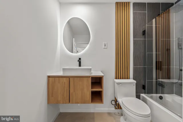 a bathroom with a toilet a sink and mirror