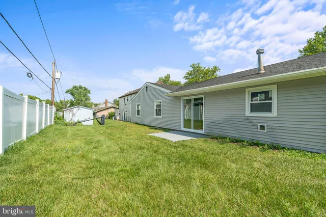 a backyard of a house with plants and wooden fence