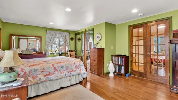a bedroom with a bed and large windows