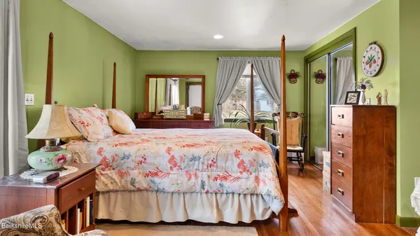 a bedroom with a large bed and a wooden floor