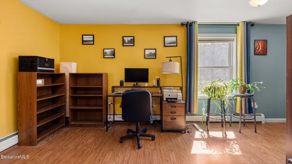 a bedroom with a bed and a painting on the wall