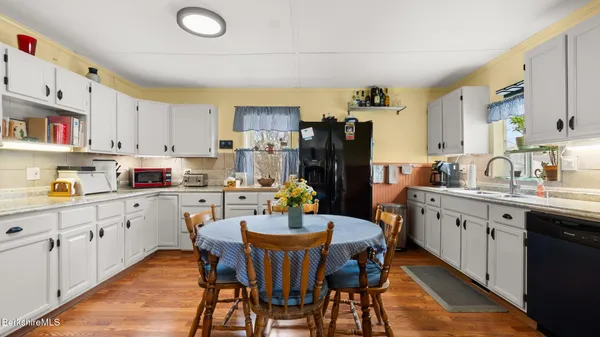 a kitchen with a dining table chairs refrigerator and cabinets