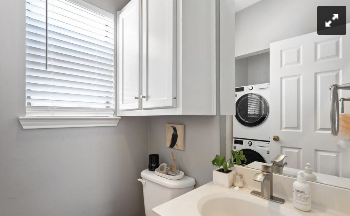 611 East 45th Street, Unit 25 Austin, TX 78751 - Photo 12 of 17 Half bathroom featuring vanity and stacked washing machine and dryer
