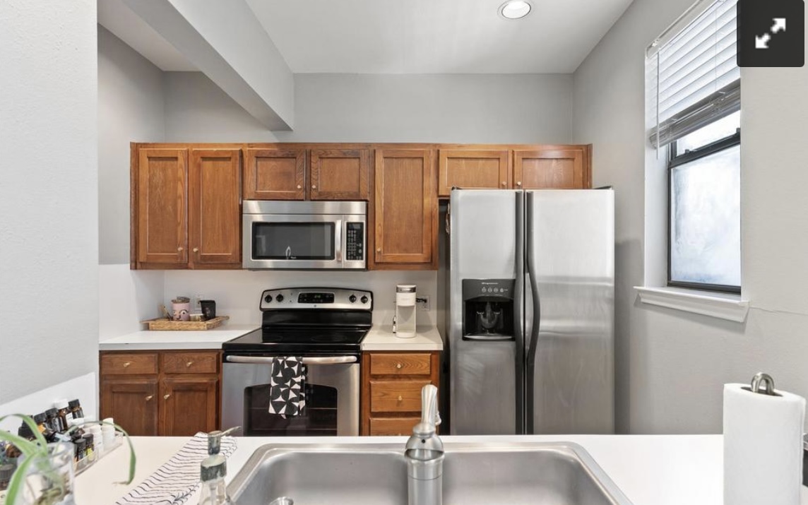 611 East 45th Street, Unit 25 Austin, TX 78751 - Photo 10 of 17 Kitchen featuring stainless steel appliances, wood finish cabinetry, and light countertops