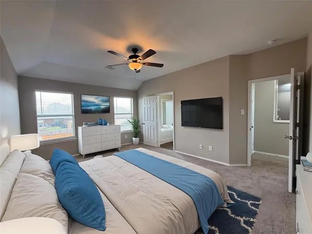a bedroom with a large bed and a flat screen tv