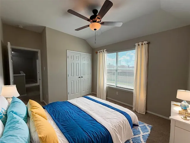 a bedroom with a bed and a large window