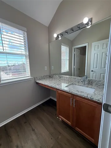 a bathroom with a granite countertop sink and a large mirror