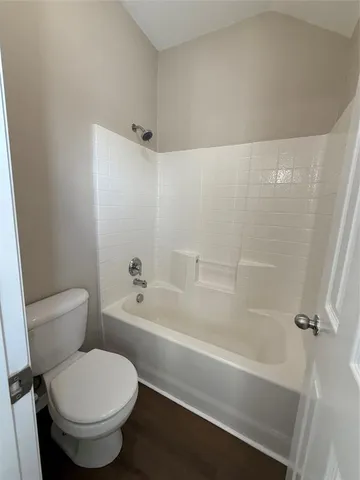 a white toilet and tub sitting next to a bathroom sink