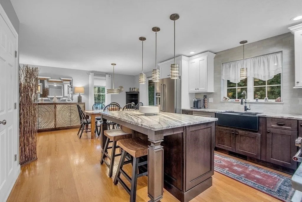 2 Morris Lane Rutland, MA 01543 - Photo 6 of 41 a open kitchen with stainless steel appliances granite countertop a stove a refrigerator a kitchen island a dining table and chairs with wooden floor