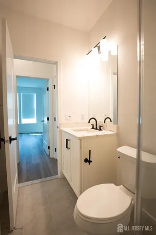 a view of an empty room with wooden floor and closet