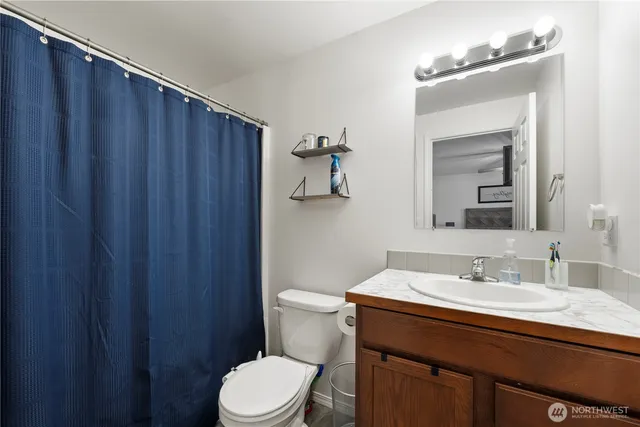 a bathroom with a sink a toilet a shower and a mirror