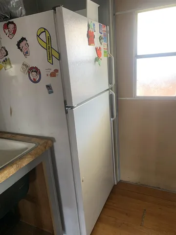 a white refrigerator freezer sitting next to a window