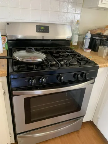 a stove top oven sitting inside of a kitchen
