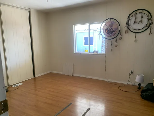 a view of a room with wooden floor and a window