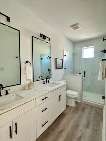 a bathroom with 2 sink toilet and shower