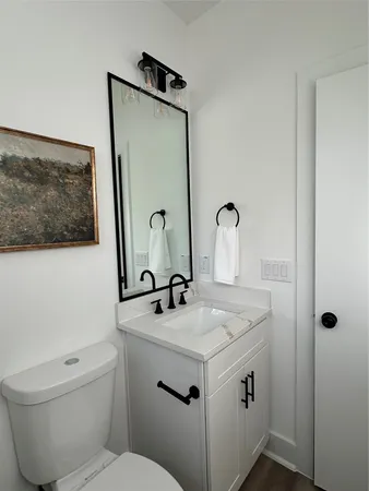 a bathroom with a sink toilet and mirror