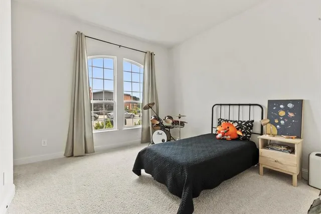 a bedroom with a bed and a large window