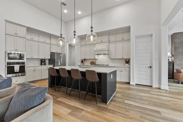 a large kitchen with kitchen island a island a stove a sink a center island and cabinets