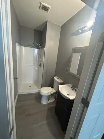 a bathroom with a toilet a sink and shower