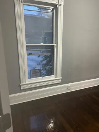 a view of a small space with wooden floor and a window