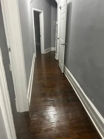a view of a hallway with wooden floor and staircase