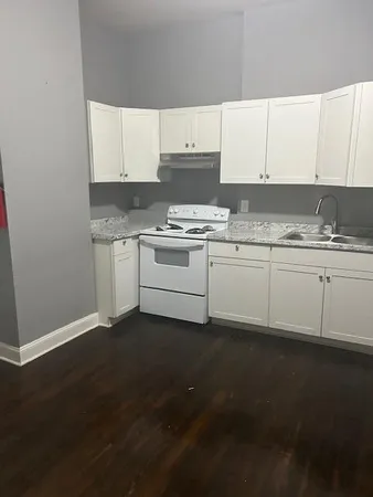 a kitchen with granite countertop a sink and a stove