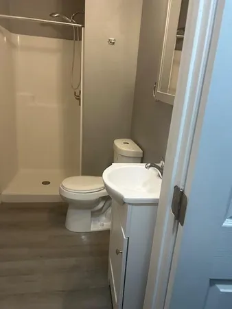 a bathroom with a sink a toilet and shower