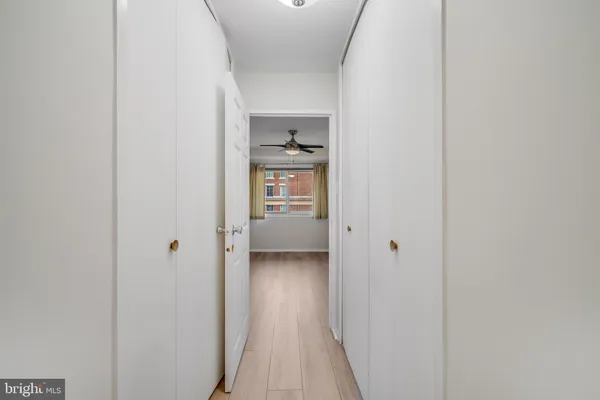 a view of a hallway with wooden floor and closet