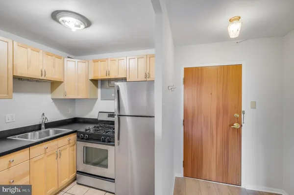 a kitchen with a refrigerator a stove a sink and cabinets