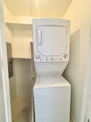 a living room with furniture kitchen view and a chandelier