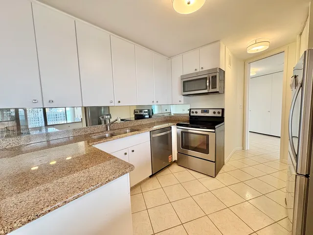 a kitchen with stainless steel appliances granite countertop a stove a sink and a microwave