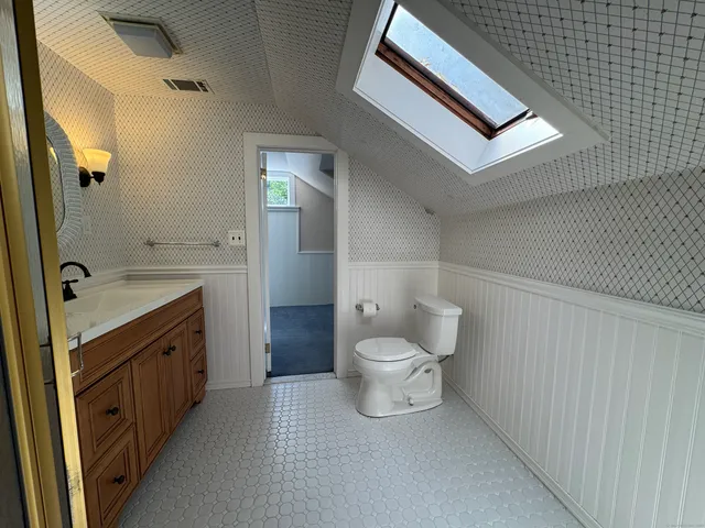 a view of a house with a yard patio and a large tree