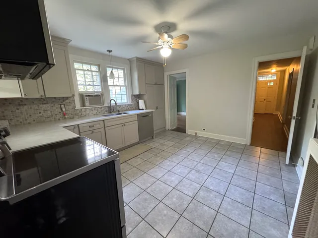 a kitchen with a sink a stove and cabinets