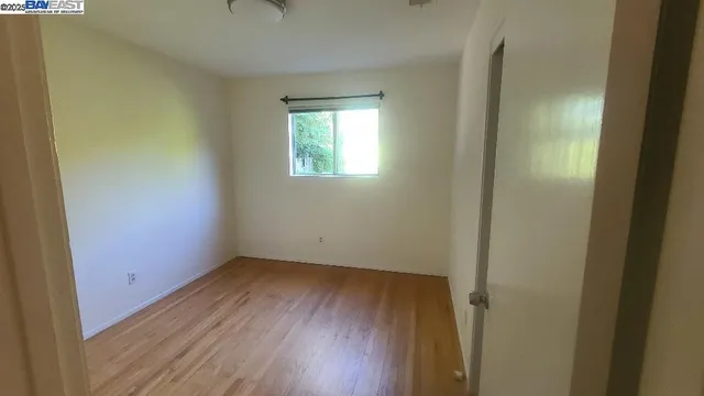 a view of a small space with wooden floor and a window