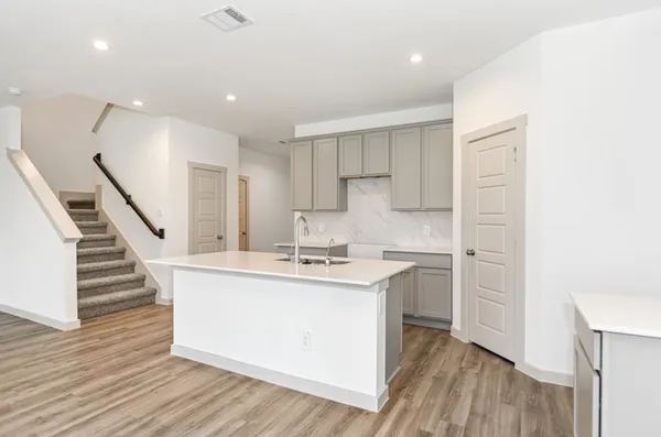 a kitchen with wooden floors and cabinets