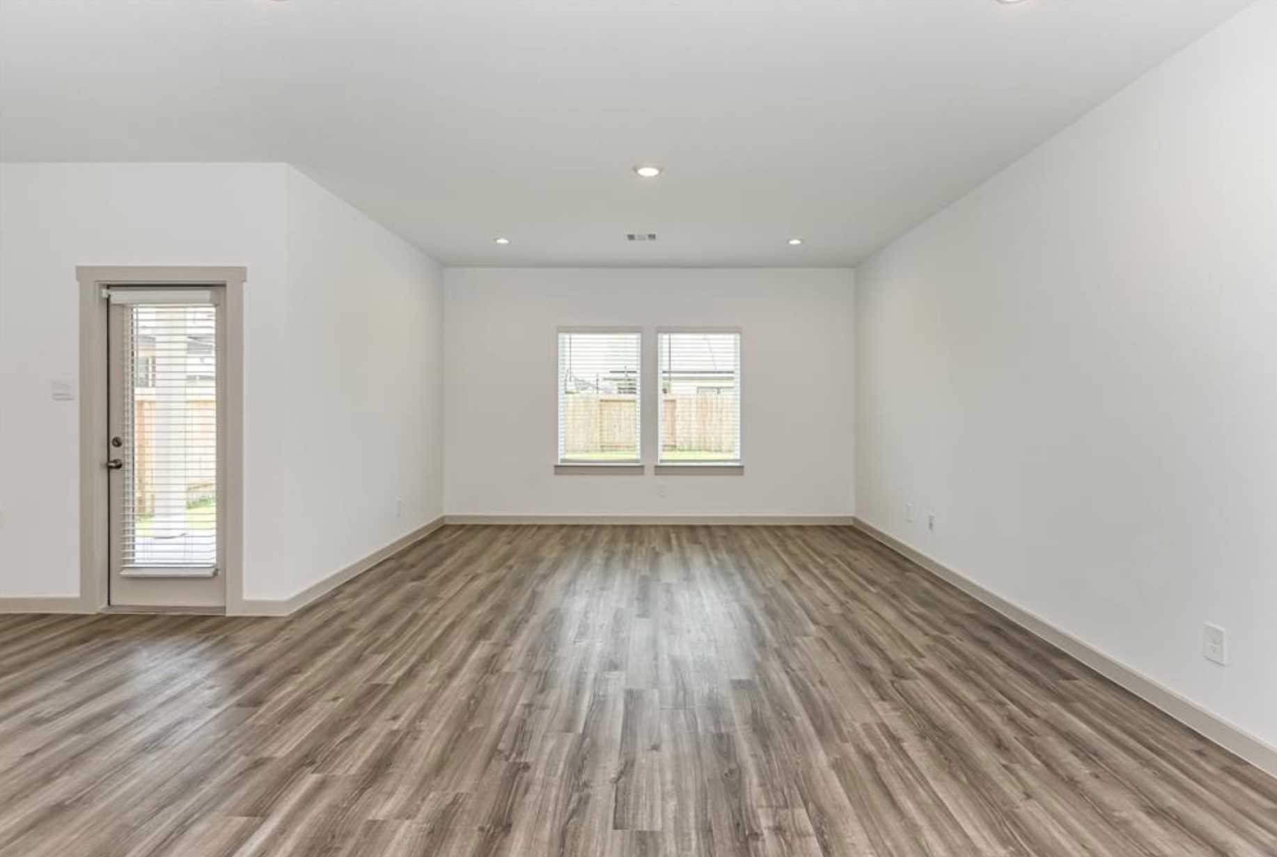 7918 Brumly Lane Rosharon, TX 77583 - Photo 9 of 34 an empty room with wooden floor and windows