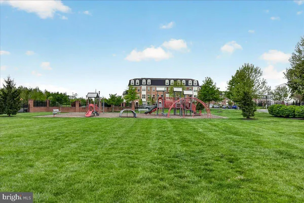 a view of outdoor space with lots of swings and slides