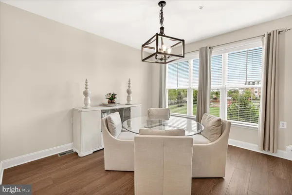 a kitchen with stainless steel appliances granite countertop a kitchen island a stove a sink dishwasher and white cabinets with wooden floor