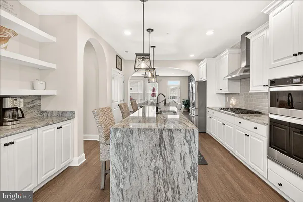 a kitchen with granite countertop a sink stove and cabinets