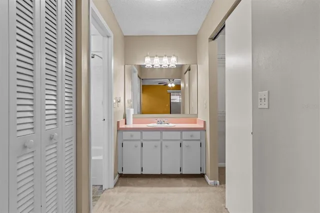 a white bath tub sitting next to a white sink and vanity