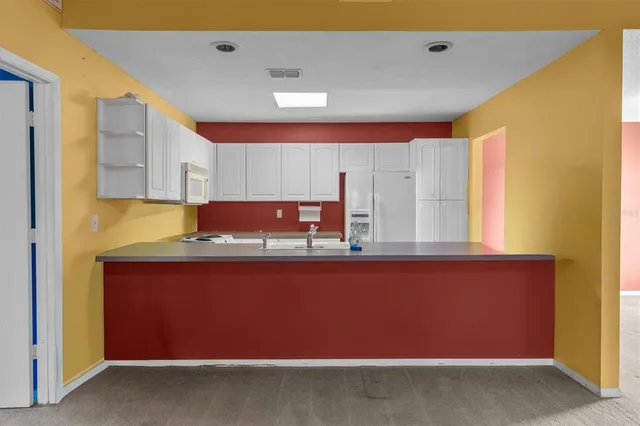 a kitchen with granite countertop white cabinets and a stove top oven