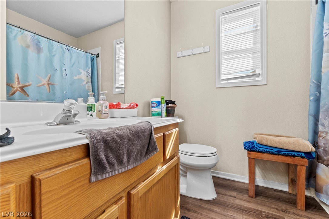 1419 Red Sunset Avenue Henderson, NV 89074 - Photo 24 of 35 Full bath with vanity, curtained shower, and dark wood finished floors