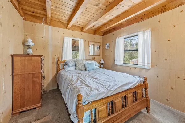 a bed sitting in a spacious bedroom next to a window