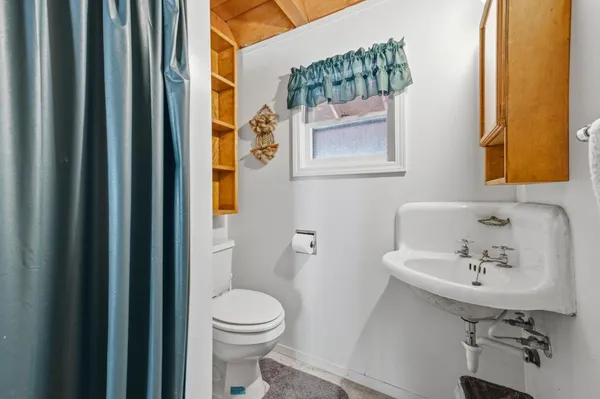a bathroom with a sink mirror and toilet